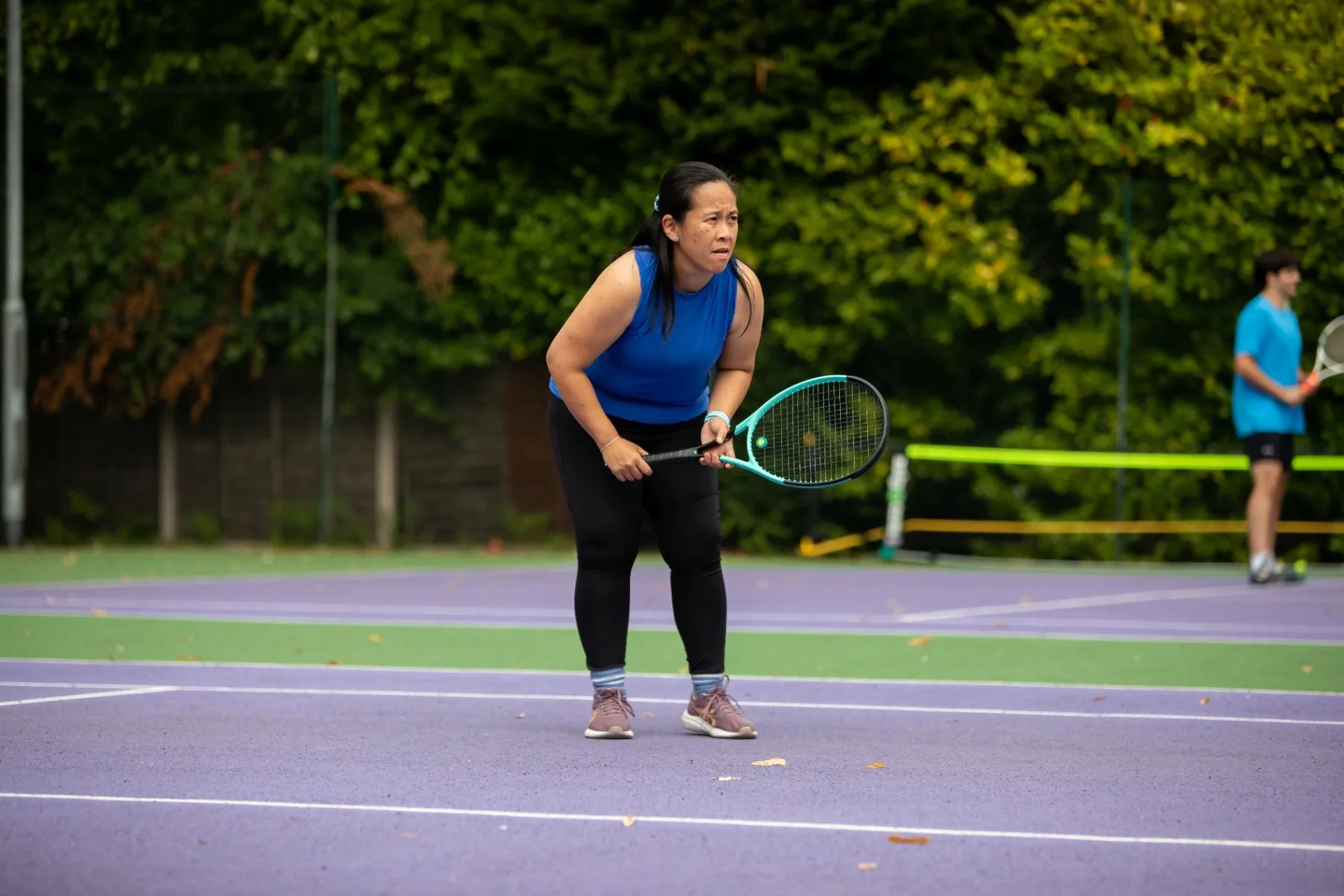 Adult tennis player ready to return a ball on an outdoor court